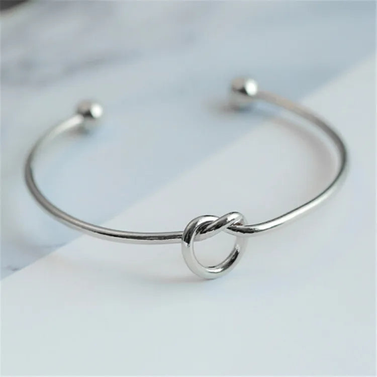 Brazalete de acero inoxidable con nudo vintage: diseño elegante y atemporal.